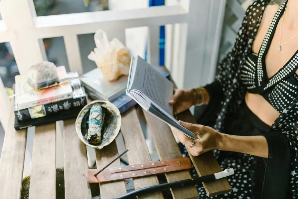 A woman reads surrounded by mystical objects, evoking a magical atmosphere.